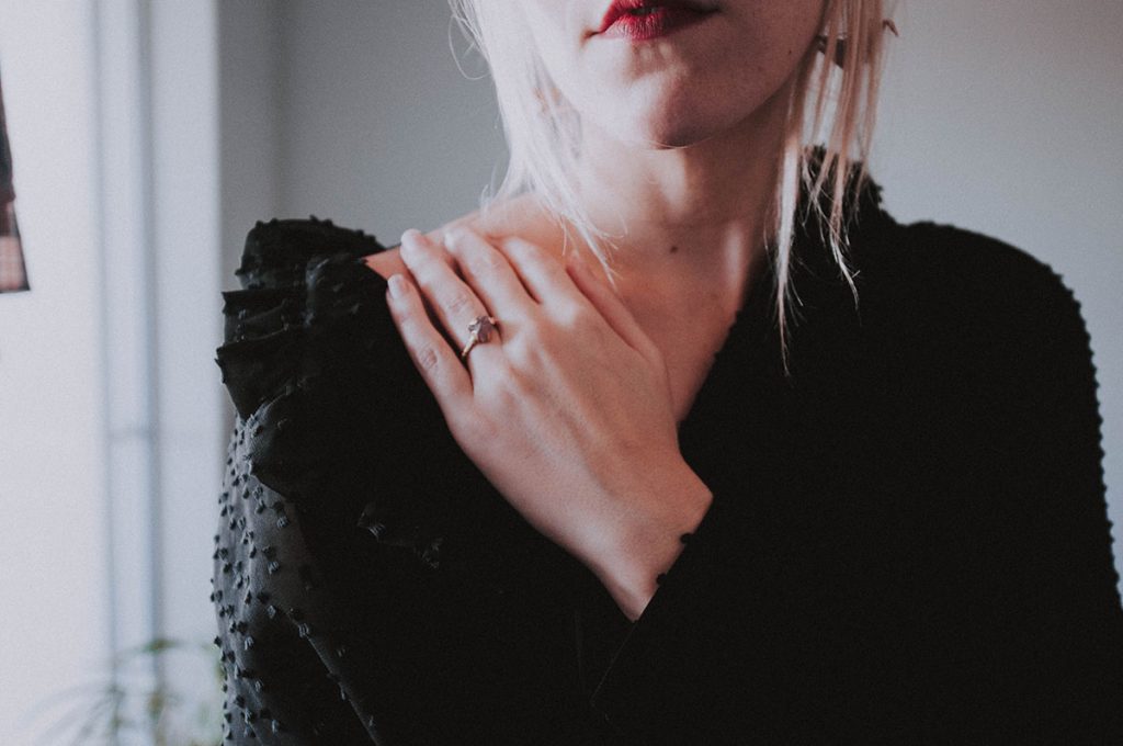 Girl in frilly black outfit and red lips, for Wuthering Heights fashion shoot.