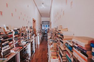 Books stacked against wall inside Bikini Beach bookshop