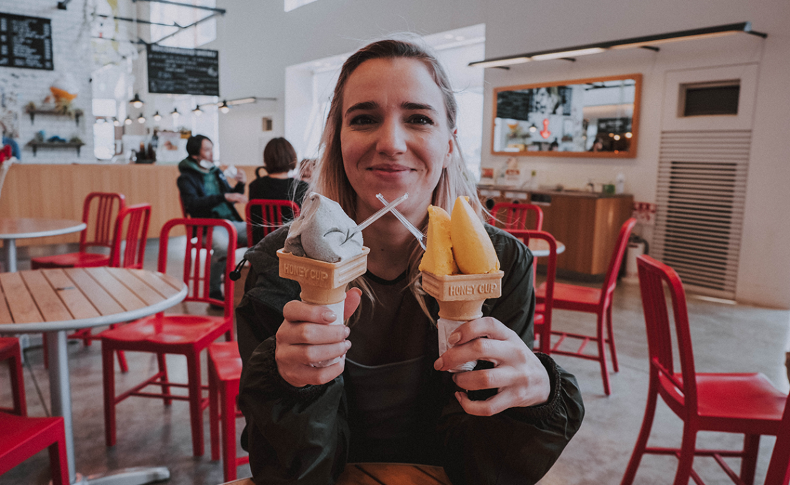 Girl holding two ice-cream cones.