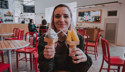 Girl holding two ice-cream cones.