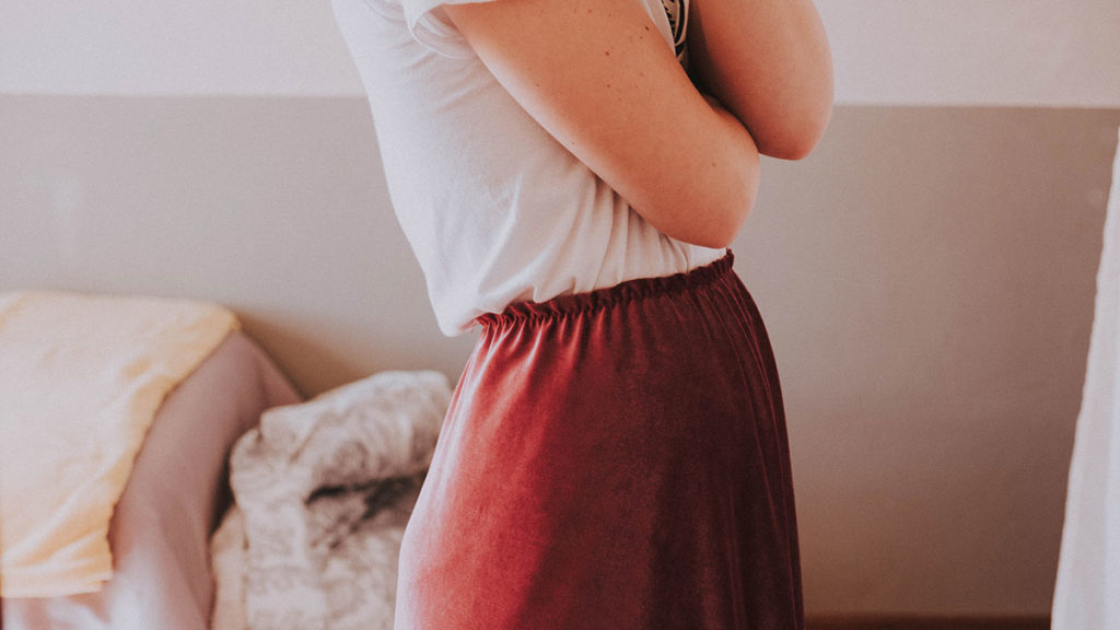 Side view of girl in velvet skirt and t-shirt.