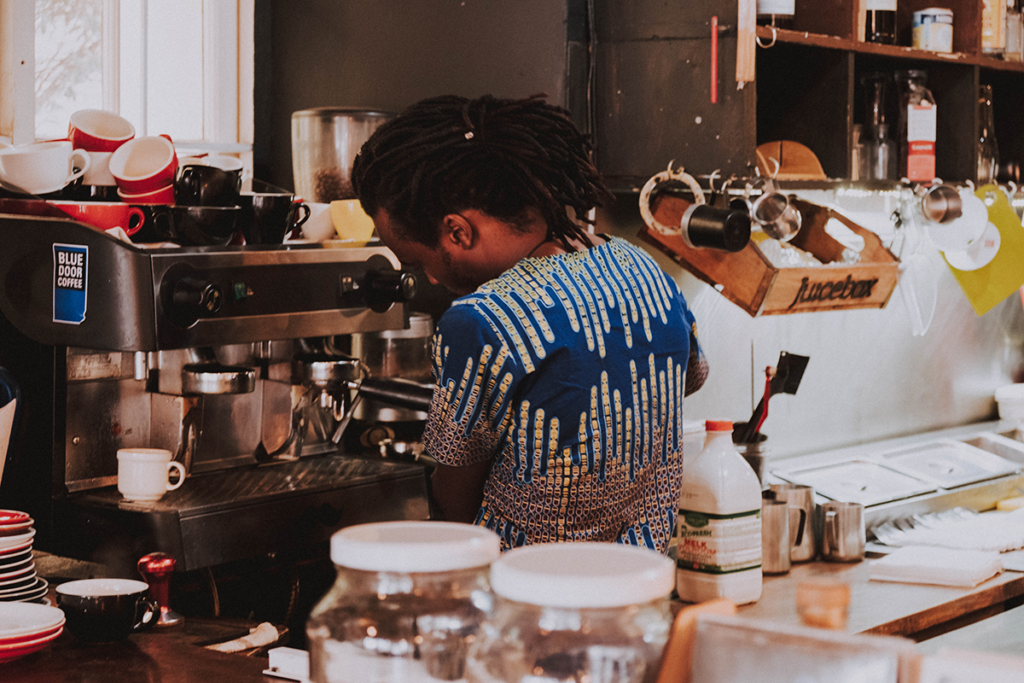 Barista in coffee shop making coffee.