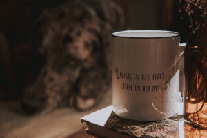 Mug with written words printed on it. Magic in the heart. Coffee in the mug.